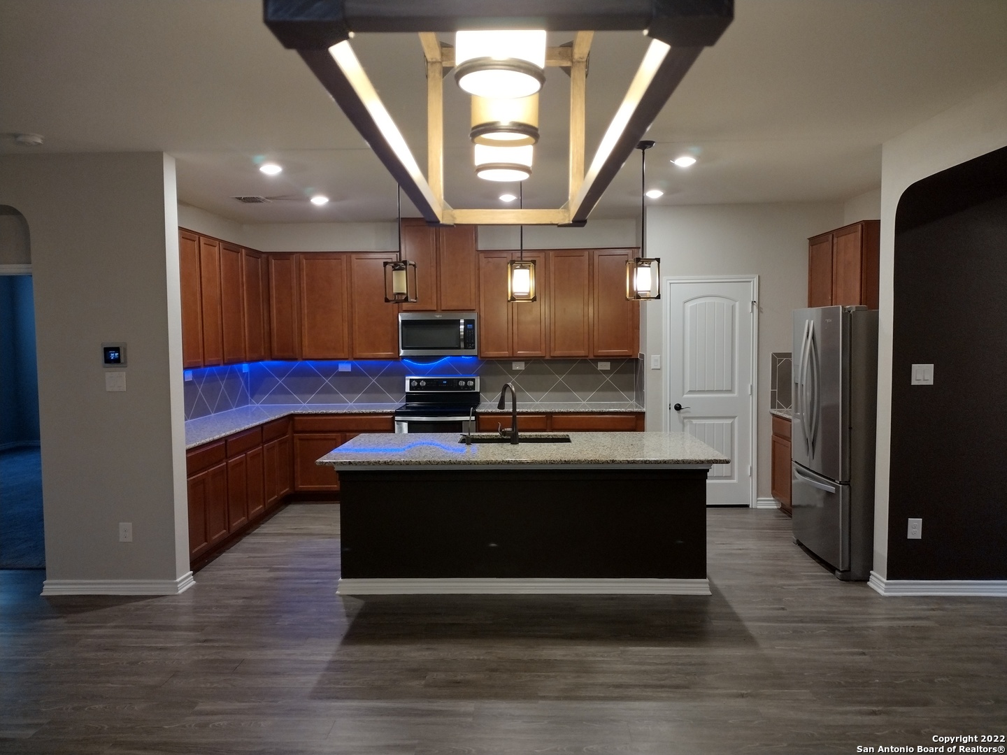11212 Hill Top Loop Helotes, TX 78023 - Photo 6 of 34 a view of kitchen with refrigerator stove and wooden floor