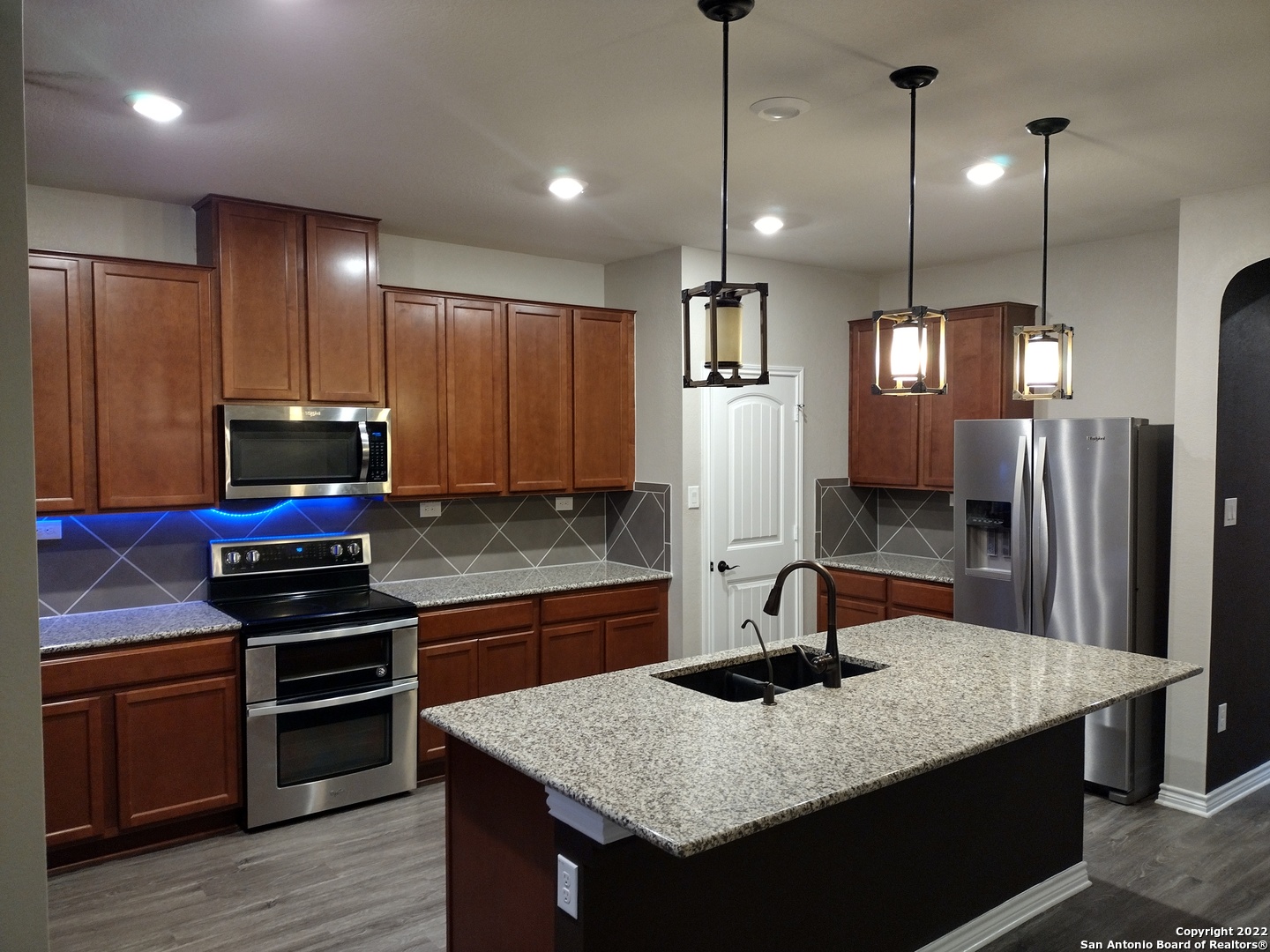 11212 Hill Top Loop Helotes, TX 78023 - Photo 9 of 34 a kitchen with kitchen island a sink stainless steel appliances and cabinets