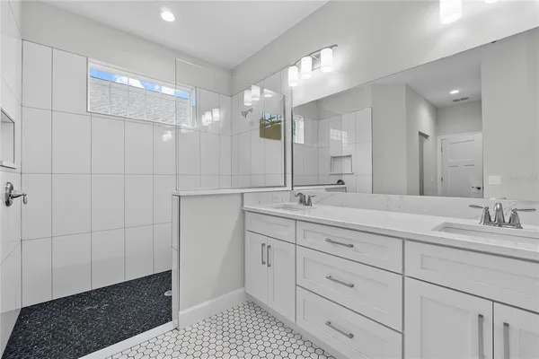 a bathroom with a double vanity sink a mirror and a shower