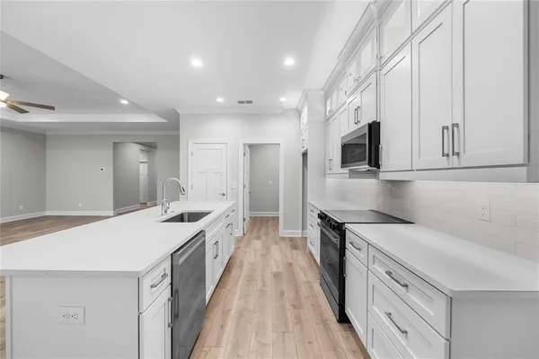 a kitchen with white cabinets appliances and sink