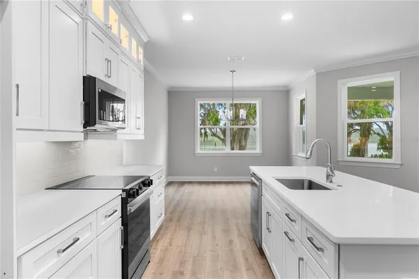 a kitchen with stainless steel appliances a sink stove and microwave