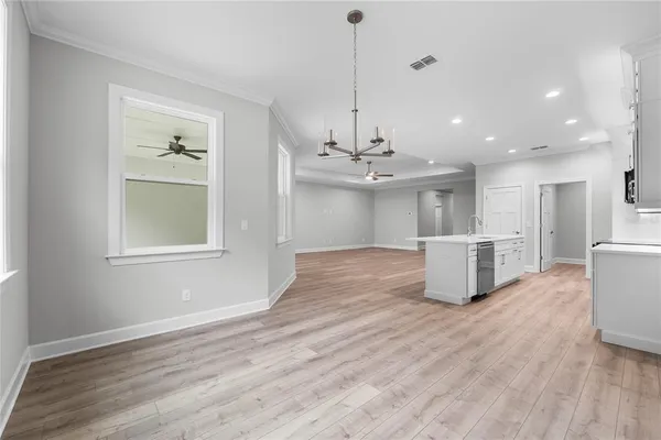 a view of a room with wooden floor staircase and a kitchen