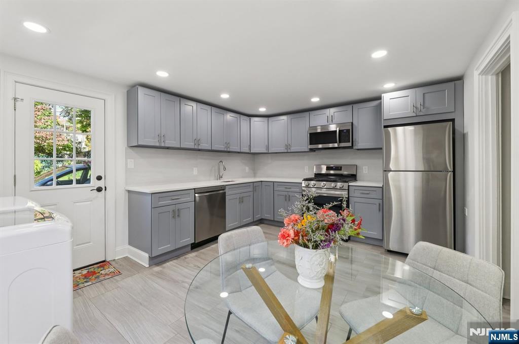 a kitchen with stainless steel appliances granite countertop a refrigerator sink stove microwave and cabinets