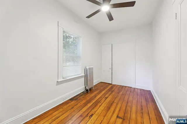 a view of a room with wooden floor closet and windows