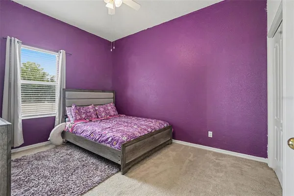 a bedroom with a bed and a chandelier fan