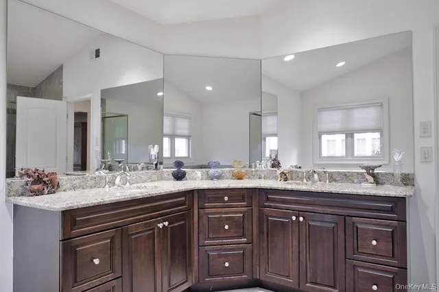 a bathroom with a granite countertop sink double and mirror