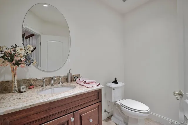 a bathroom with a granite countertop sink mirror and toilet