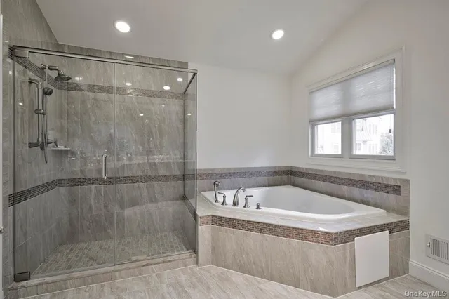 a white bath tub sitting next to a shower
