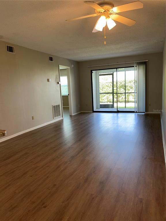 26485 Rampart Boulevard, Unit D1 Punta Gorda, FL 33983 - Photo 2 of 29 an empty room with wooden floor and windows