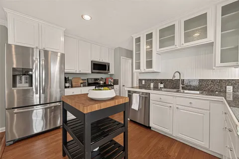 a kitchen with white cabinets and sink