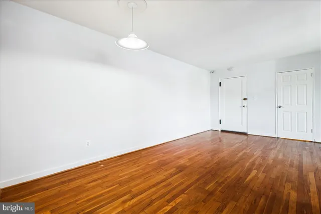 a view of empty room with wooden floor
