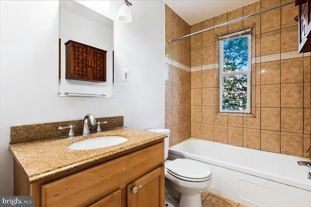 a bathroom with a granite countertop sink a toilet and a mirror