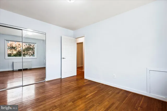 an empty room with wooden floor and window