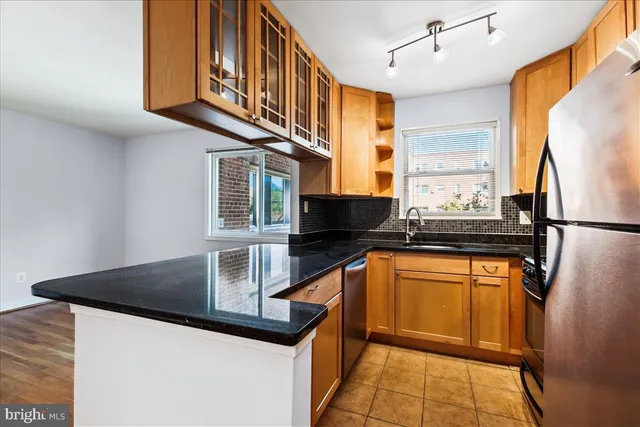 a kitchen with stainless steel appliances granite countertop a sink a stove and a refrigerator