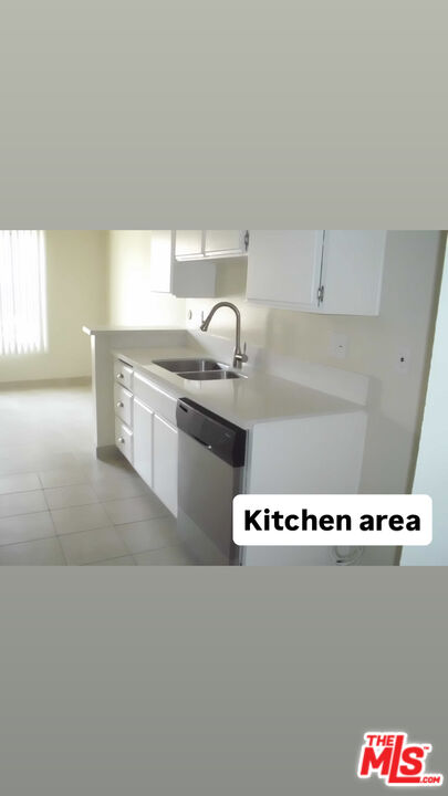 12940 Riverside Drive, Unit 102 Sherman Oaks, CA 91423 - Photo 4 of 10 a kitchen with granite countertop a stove and white cabinets