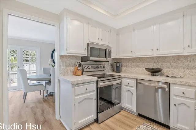 a kitchen with stainless steel appliances granite countertop a stove and white cabinets