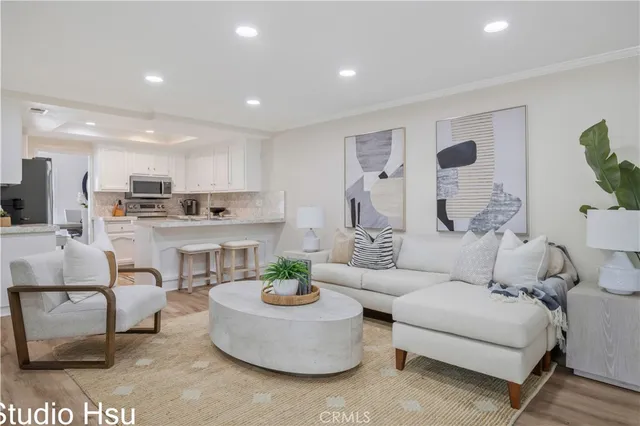 a living room with furniture and a dining table with kitchen view