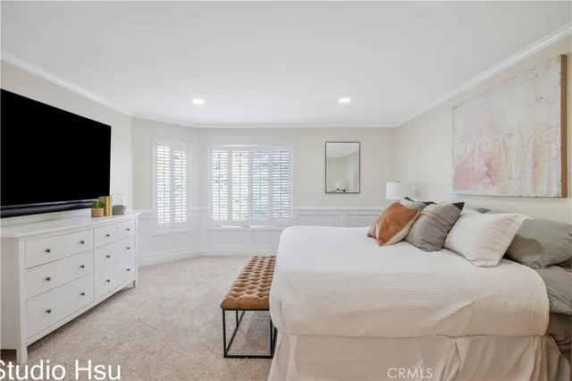 a bedroom with a bed and a flat screen tv on dresser