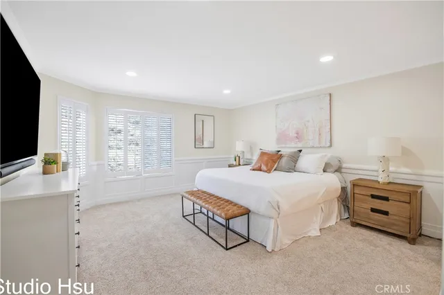 a spacious bedroom with a bed a couch and a large window