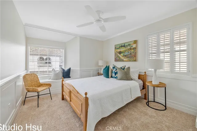 a bedroom with a bed a chair and a large window