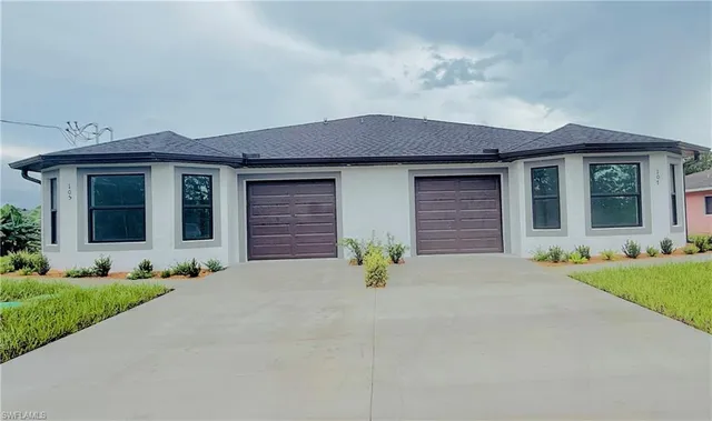 a front view of a house with a yard and outdoor seating