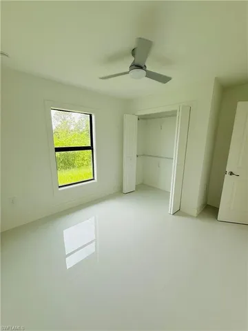 an empty room with windows and closet
