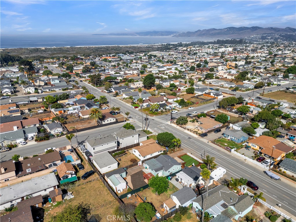 848 Mentone Avenue Grover Beach, CA 93433 - Photo 3 of 33 an aerial view of a city with lots of residential buildings and mountain view in back