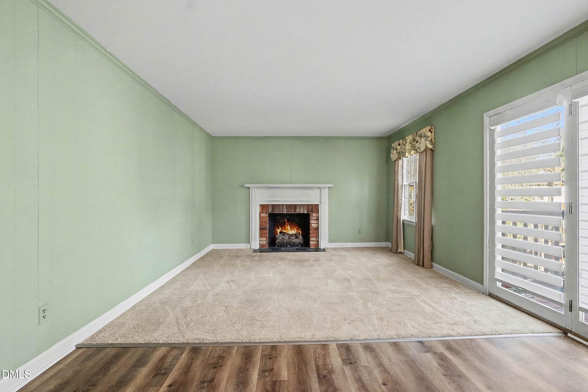 3704 Pembrook Place Raleigh, NC 27612 - Photo 20 of 68 a view of an empty room with a fireplace and a window