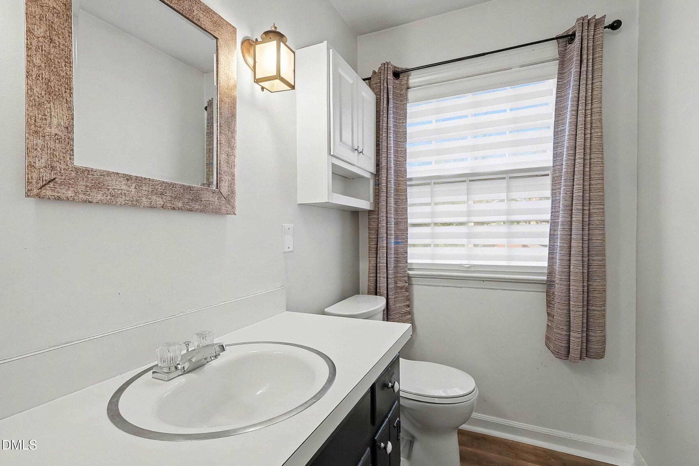 3704 Pembrook Place Raleigh, NC 27612 - Photo 24 of 68 a bathroom with a sink a toilet and a mirror