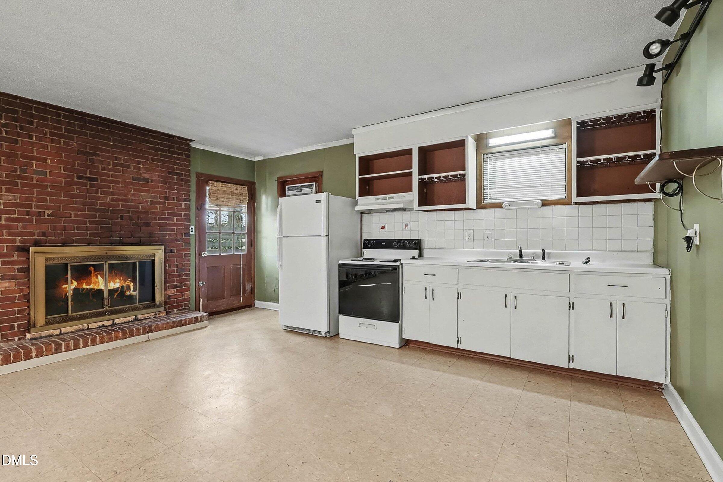 3704 Pembrook Place Raleigh, NC 27612 - Photo 42 of 68 a open kitchen with granite countertop a stove top oven a sink dishwasher and a fireplace with wooden floor