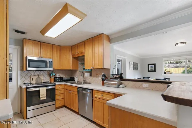 a kitchen with granite countertop a sink stainless steel appliances and cabinets