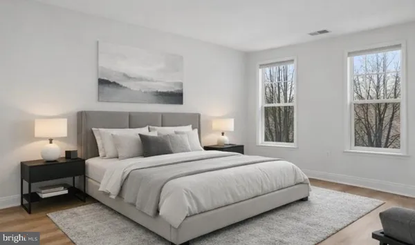 a bedroom with a bed and wooden floor