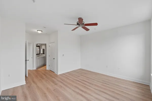 a view of a room with wooden floor and a ceiling fan