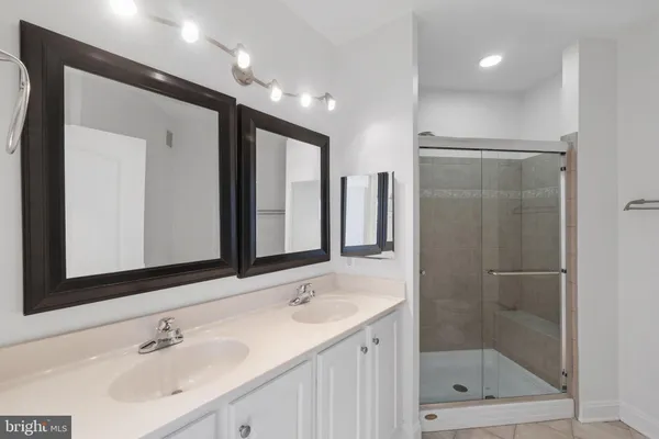 a bathroom with a shower sink and mirror