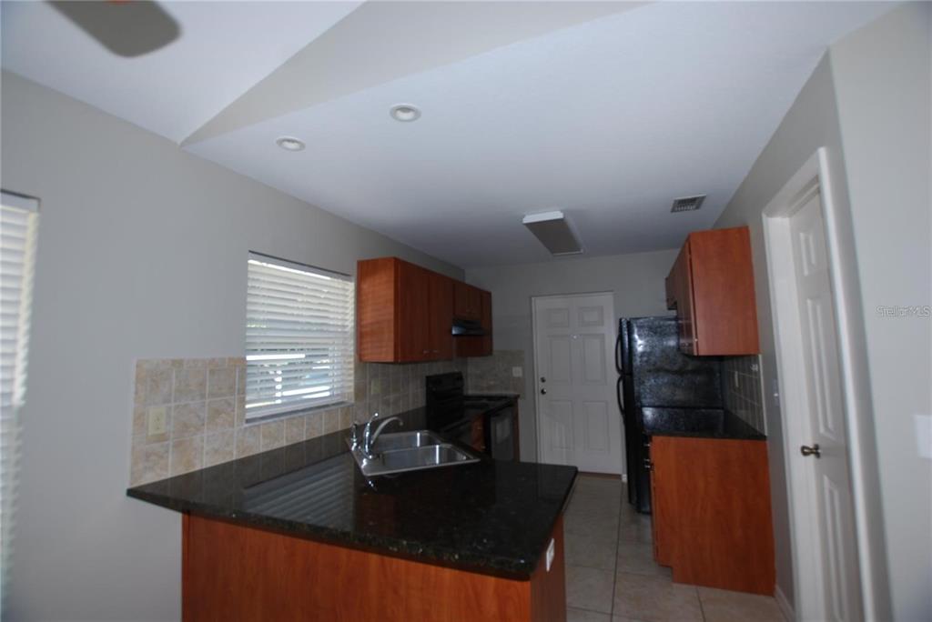312 East Hibiscus Drive Lakeland, FL 33803 - Photo 3 of 25 a kitchen with granite countertop a sink stove and refrigerator