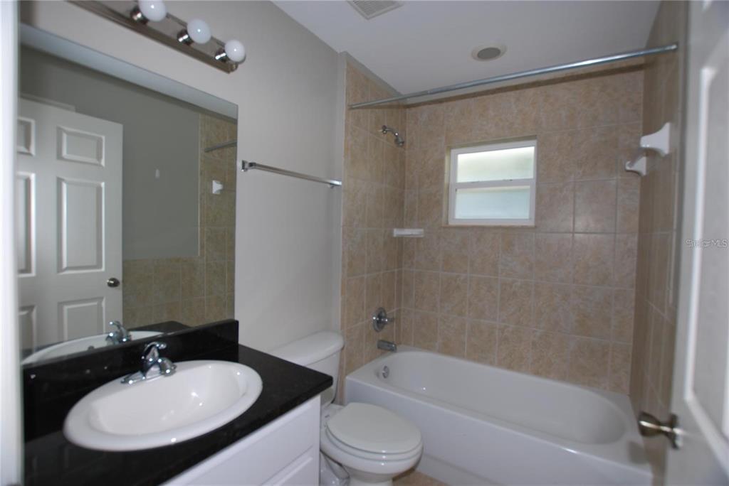 312 East Hibiscus Drive Lakeland, FL 33803 - Photo 8 of 25 a bathroom with a bathtub shower sink vanity mirror and toilet