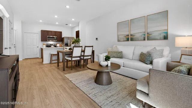 a living room with furniture and view of kitchen