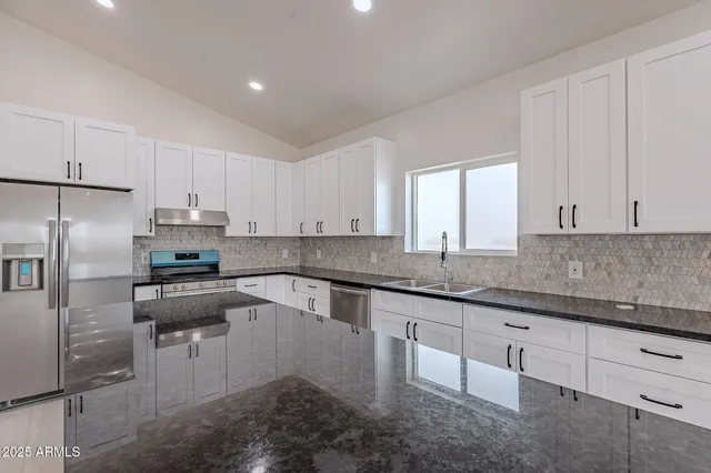a kitchen with granite countertop white cabinets white appliances and granite counter tops