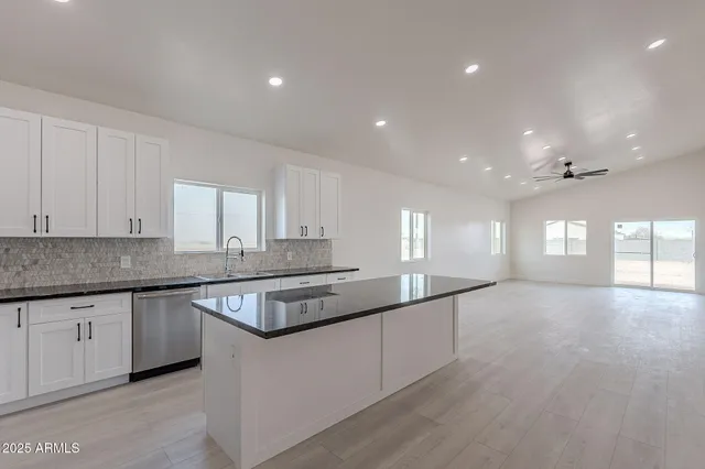 a kitchen with granite countertop a stove and white cabinets