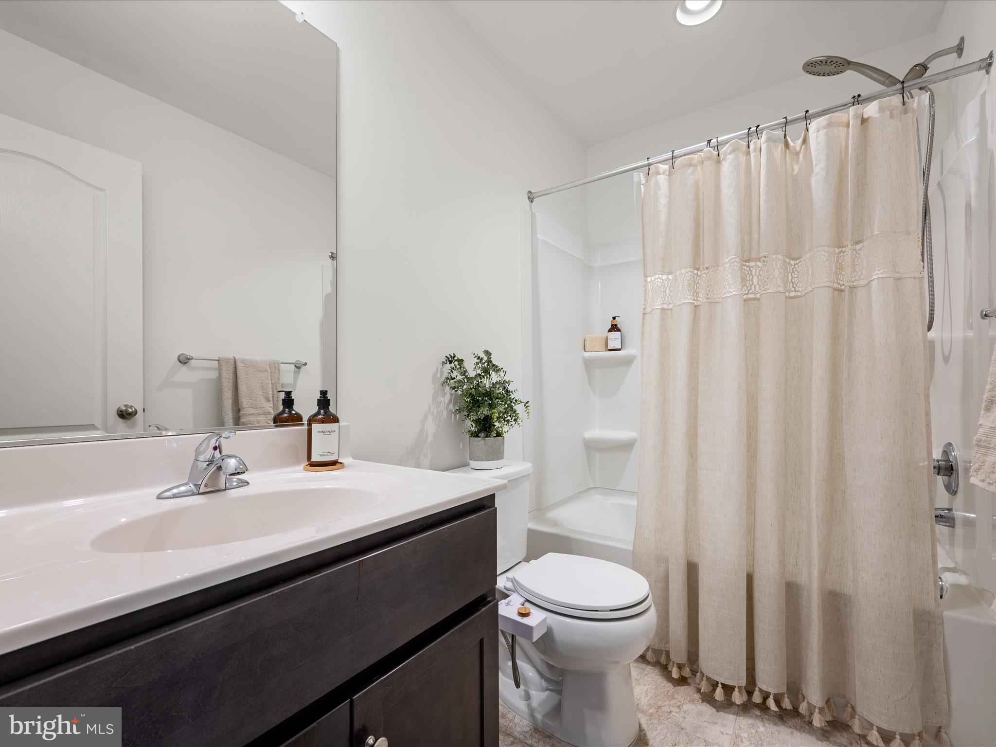 576 Thumper Drive Ranson, WV 25438 - Photo 28 of 37 a bathroom with a sink a toilet and shower curtain