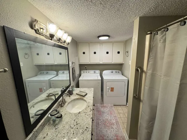 a kitchen with granite countertop a sink a stove and cabinets