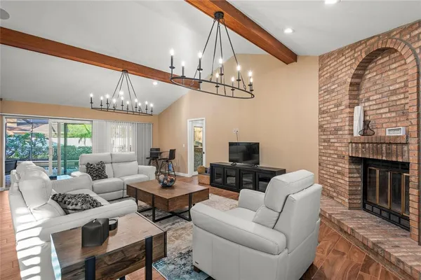 a living room with furniture a chandelier and a fireplace