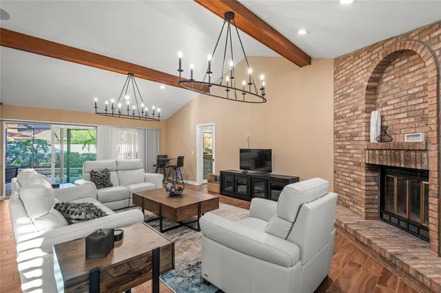 a living room with furniture a chandelier and a fireplace