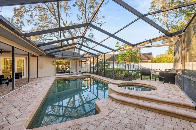 a view of a swimming pool with a patio and a yard