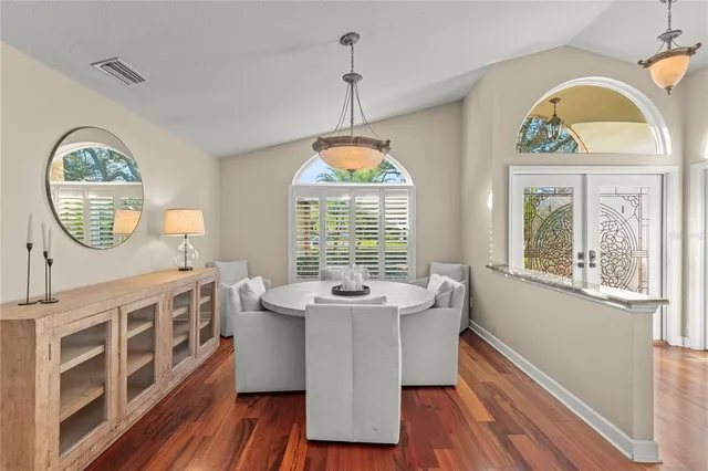 a living room with furniture a chandelier and wooden floor