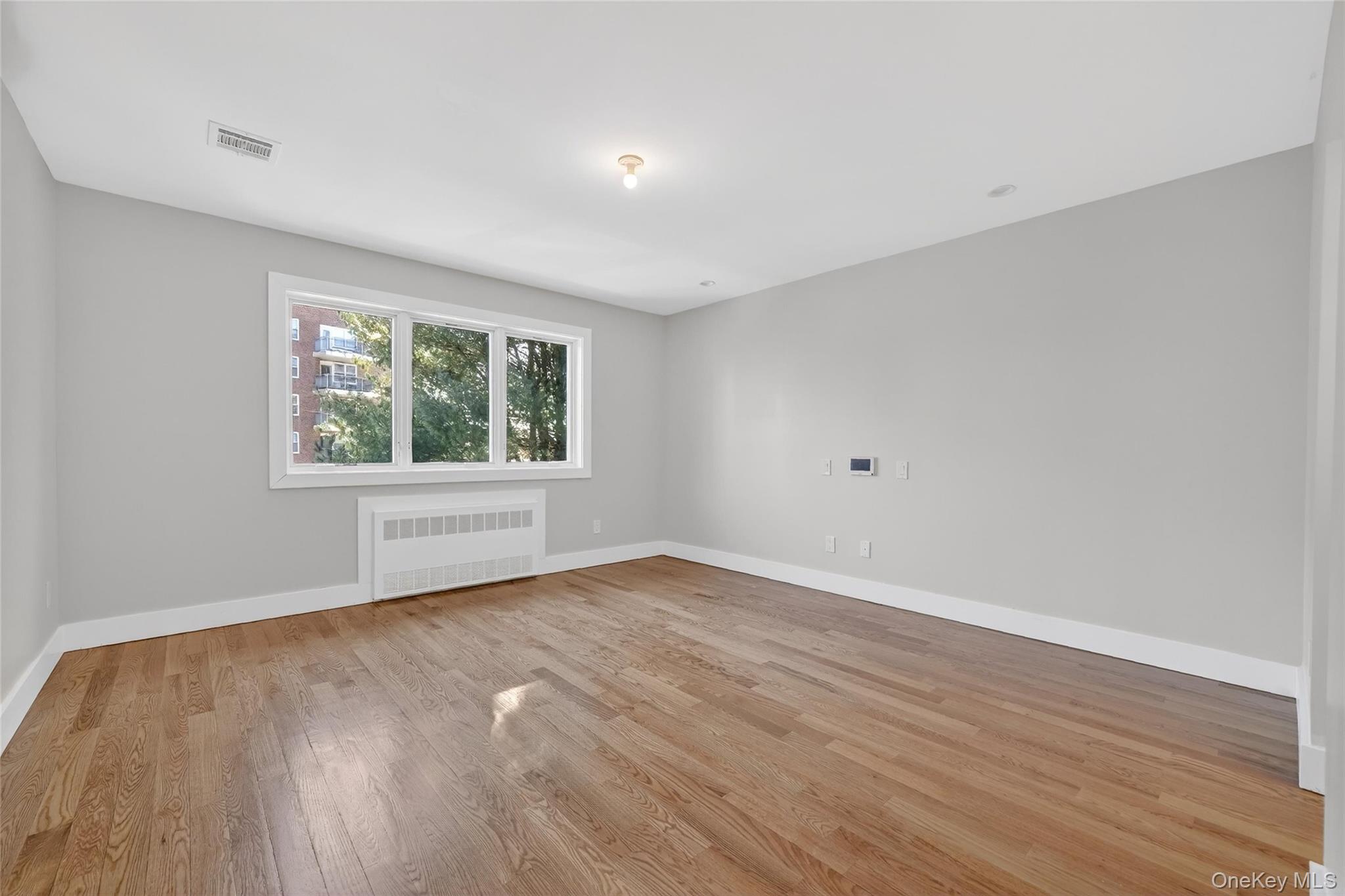 35 South Cole Avenue, Unit 202 Spring Valley, NY 10977 - Photo 26 of 50 a view of an empty room with wooden floor and a window