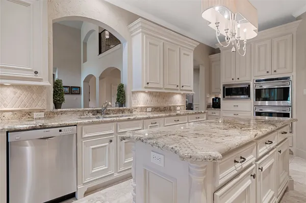 a kitchen with stainless steel appliances granite countertop a sink stove and cabinets