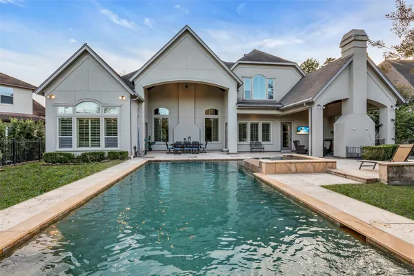 a view of a house with swimming pool and a yard