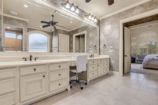 a spacious en suite bathroom with double sink a large mirror and a shower