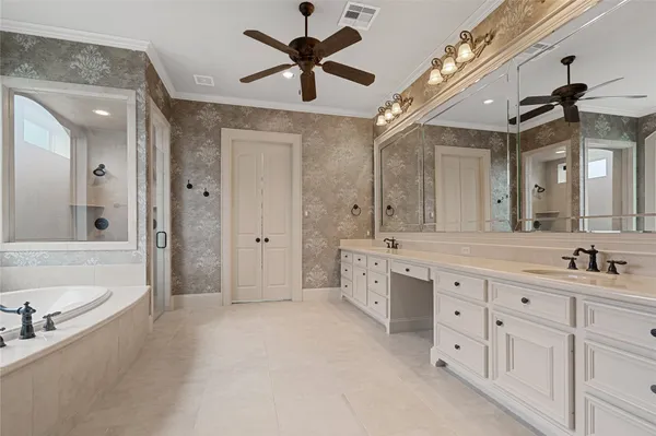 a spacious bathroom with a double vanity sink a mirror a bathtub and a shower